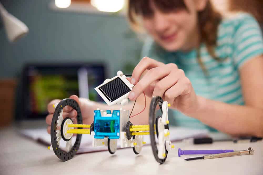 teenage girls building solar powered robot