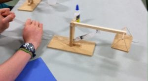 Teens build mini hydraulic lifts.