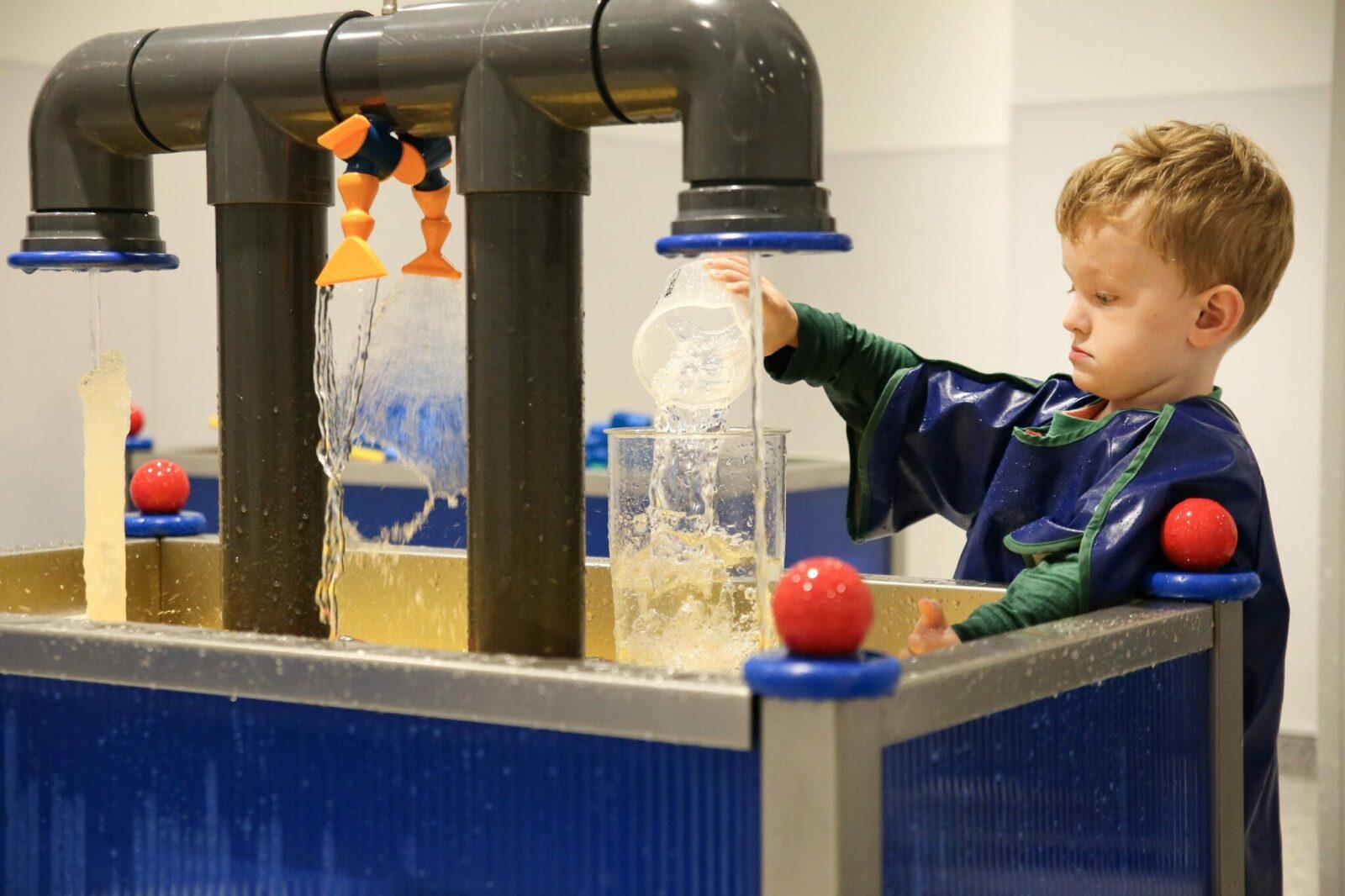 Young boy playing in the water gallery at the Discovery Museum