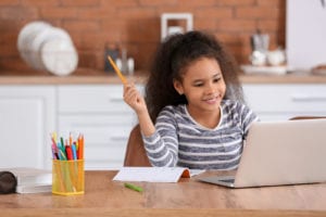 Girl_working_on_her_laptop_in_kitchen