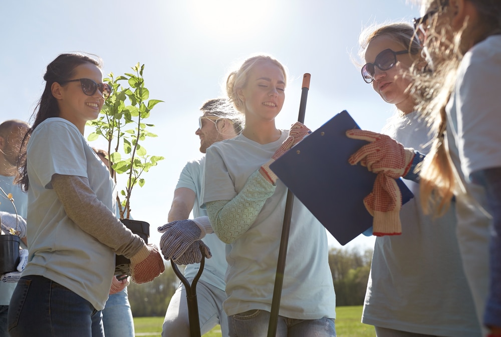 students volunteers outside planting tree