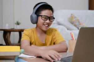 cheerful boy using computer for online instruction