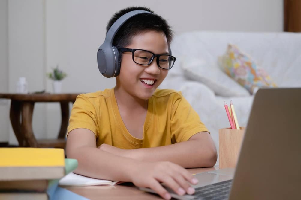 cheerful boy using computer for online instruction