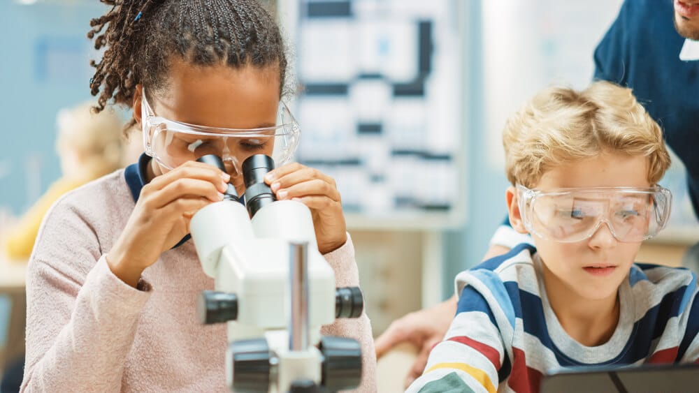 female-student-in-science-class-using-microscope