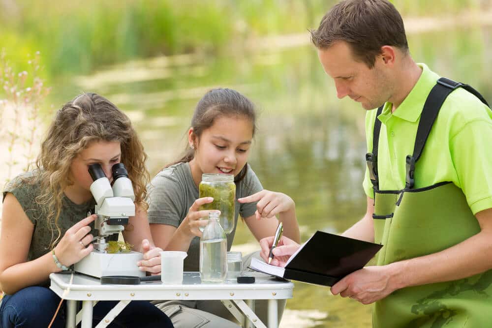 Young girls having an outdoor science lesson with an instructor