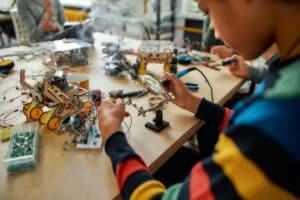 teen boy uses solder for a project