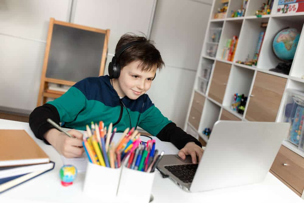 4th grade boy taking a virtual class at home on computer