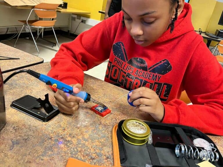 Student is soldering components for their team's NASA TechRise 2023-24 experiment