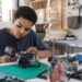teen boys solders wires to build a robot
